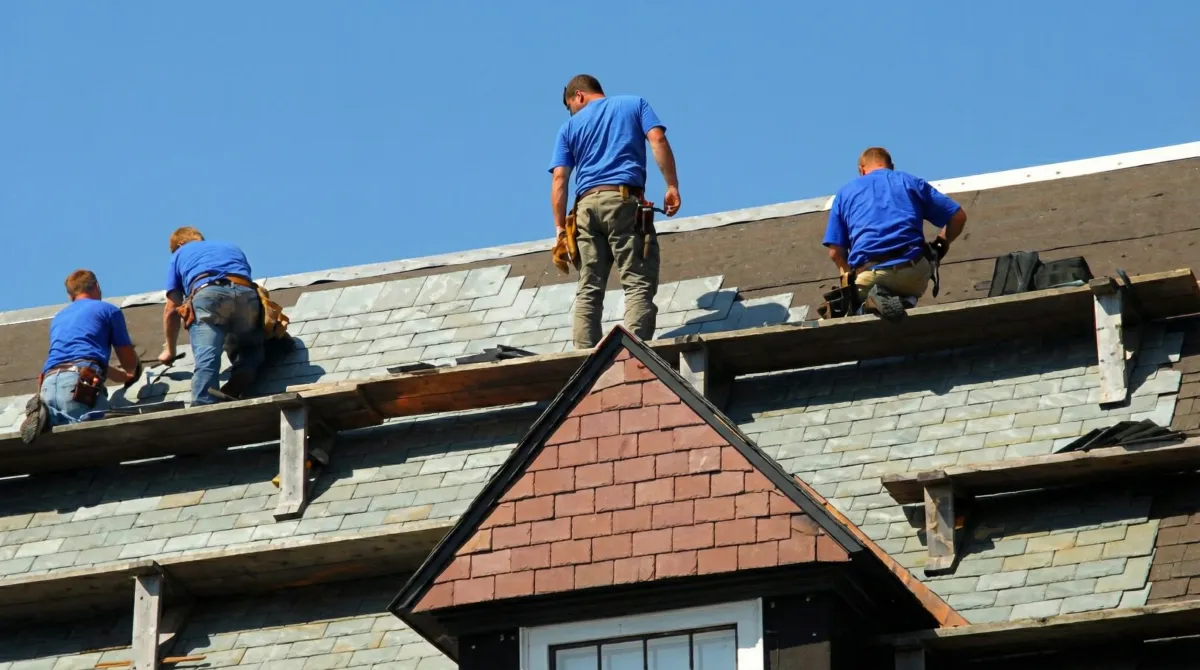Roof replacement in progress with a team of professional contractors installing new shingles on a residential home in Green Bay, WI